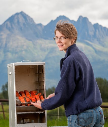 Photo by Edwin Remsberg. Julie Cascio prepares to smoke salmon in Mat-Su. Her first food preservation class on July 30 will demonstrate how to smoke and can fish.