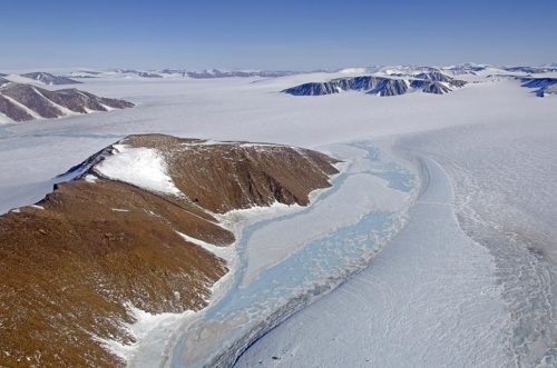 Photo by NASA/Michael Studinger. Mountains interrupt the Greenland ice sheet.