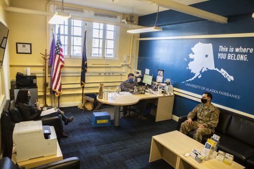 Three people sitting in the military and veterans service office. 
