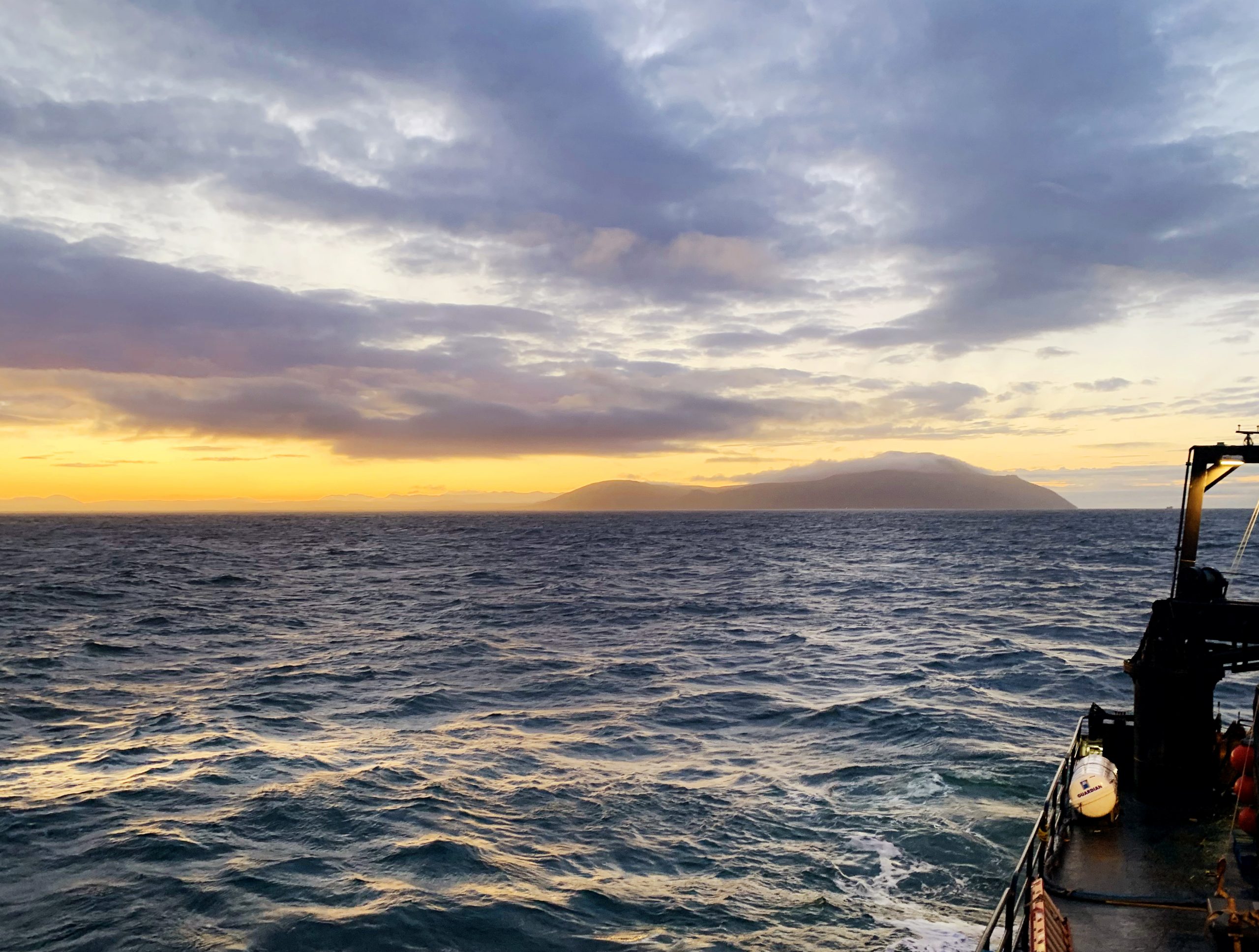 Photo by Jordi Maisch. The Cape Prince of Wales, the westernmost point of mainland North America, rises on the east coast of the Bering Strait in this view from the Norseman II in October 2020.