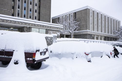 Heavy snow covers vehicles in the parking lot outside the Moore-Bartlett-Skarland Complex after a winter storm in November 2020. UAF photo by JR Ancheta.