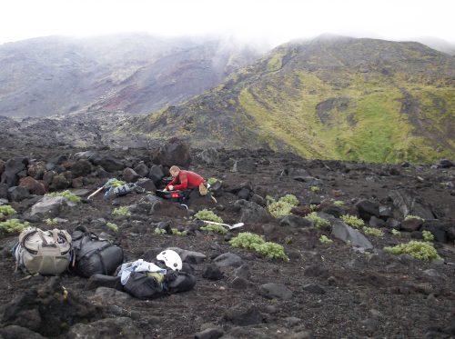 Photo by Diana Roman. Pete Stelling, formerly of Western Washington University, assembles a seismic station on Cleveland Volcano in August 2015.