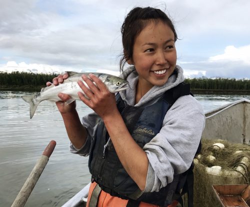 Graduate student Elizabeth Mik’aq Lindley (Yup’ik) holds a sockeye salmon at the Alaska Department of Fish and Game lower Kuskokwim sonar site in 2017. Photo courtesy of Elizabeth Mik’aq Lindley / ADF&G.