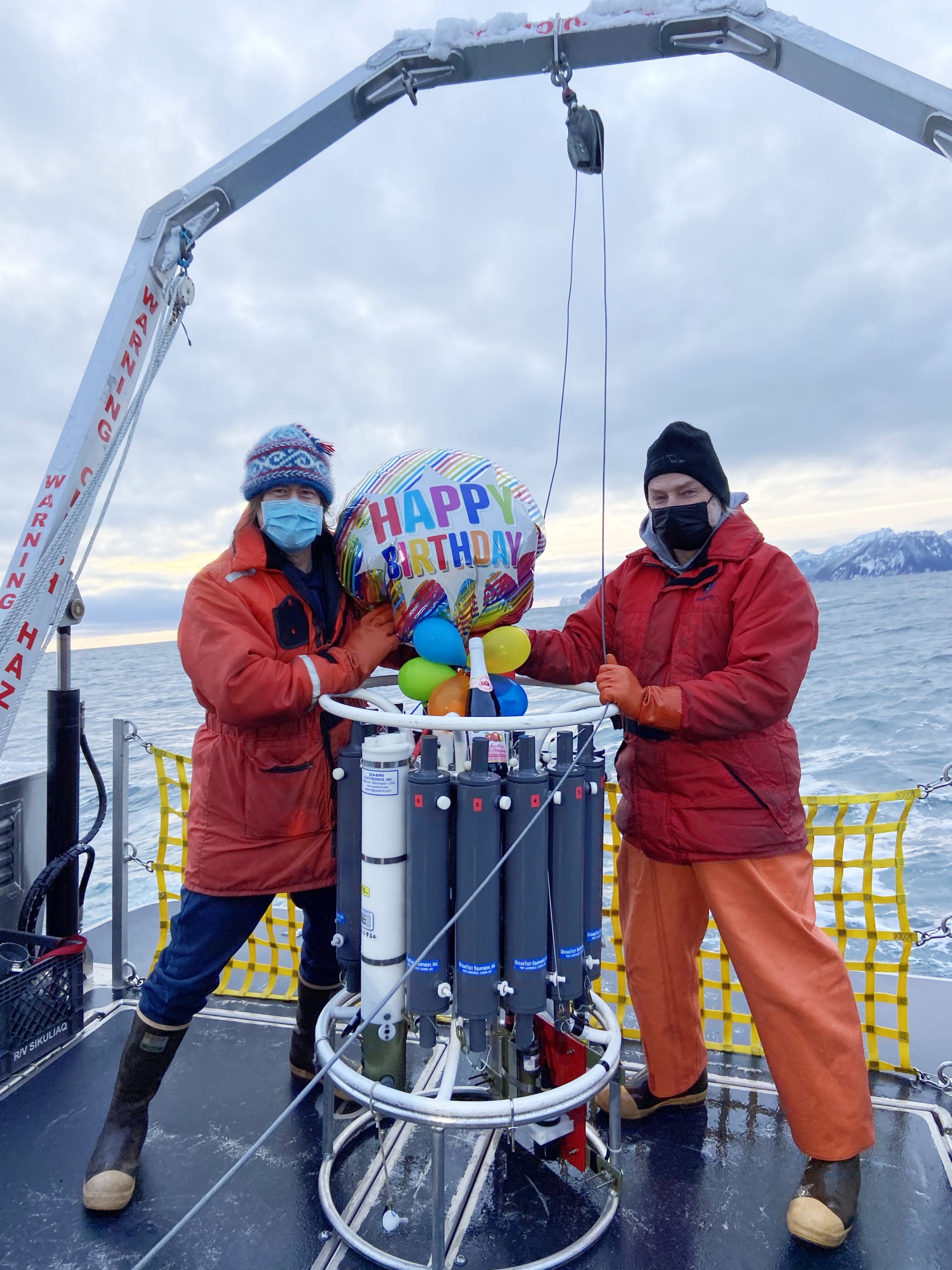 Photo by Gillian Braver. UAF faculty members Seth Danielson, left, and Russ Hopcroft join Seward Marine Center staff to celebrate the 50th anniversary of the GAK-1 oceanographic station aboard Nanuq in December 2020.
