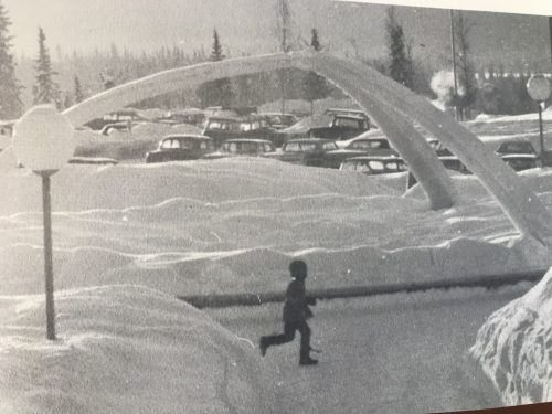 Photo courtesy of Alan Straub. A child runs across Cornerstone Plaza in front of a newly constructed ice arch at the University of Alaska in 1966.