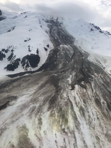 Photo by Loren Prosser, courtesy of Alaska Volcano Observatory.. Newly disturbed rocks and ice lie on Red Glacier a few days after an avalanche in June 2019.