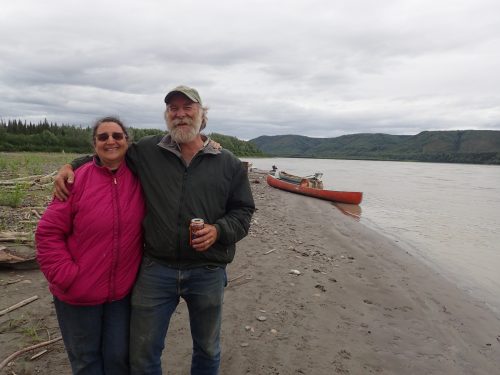 Photo by Ned Rozell. Randy Brown and his wife, Karen Kallen-Brown, stand on the Yukon River's bank at their fish camp in July 2018.