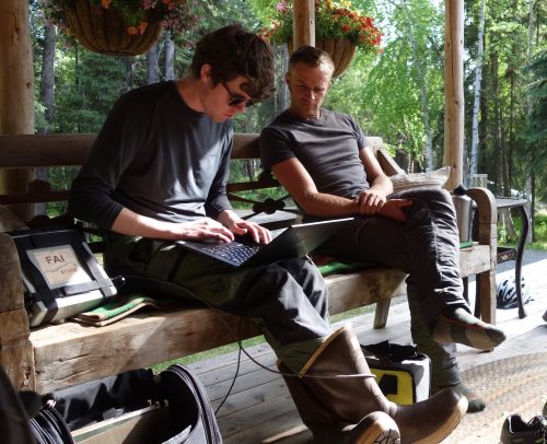 Photo by Ned Rozell. On a Fairbanks homeowner’s porch, Nicholas Hasson, left, and Jason Clark of UAF review results from permafrost investigations.