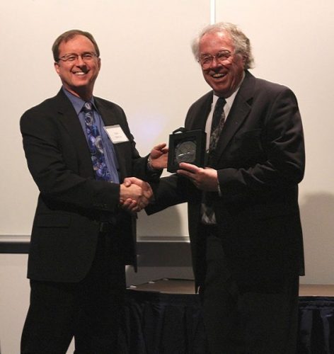 Photo courtesy of the Geophysical Institute. Neal Brown accepts the Roger Smith Lifetime Achievement award in 2016 from Bob McCoy, director of the UAF Geophysical Institute.
