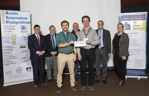 ACEP's Riley Bickford (front, left) and Tom Marsik (front, right) receive their Arctic Kicker prize during the Arctic Innovation Competition. Behind them are Ping Lan and Mark Herrmann (School of Management), UAF photo by JR Ancheta.
