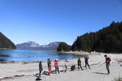 Students gather on a beach on one of the Inian Islands as part of the 2021 learning intensive offered by the Climate Scholars Program. Photo courtesy of the Honors College.