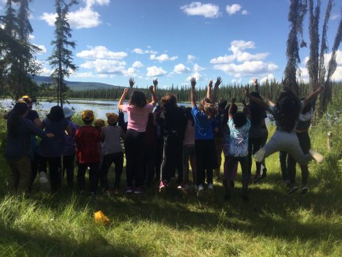 Photo courtesy of Christa Mulder. Campers in the Fostering Science program's Bonanza Creek Adventure Camp jump together while visiting Smith Lake on the Fairbanks campus.