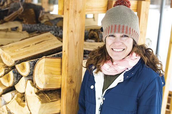 woman in front of wood pile
