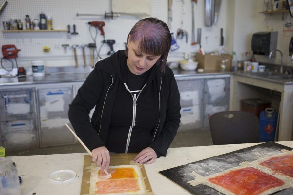 Annie Duffy demonstrates a mixed-media technique for her spring 2016 advanced painting class. Photo by Alyssa Enriquez.