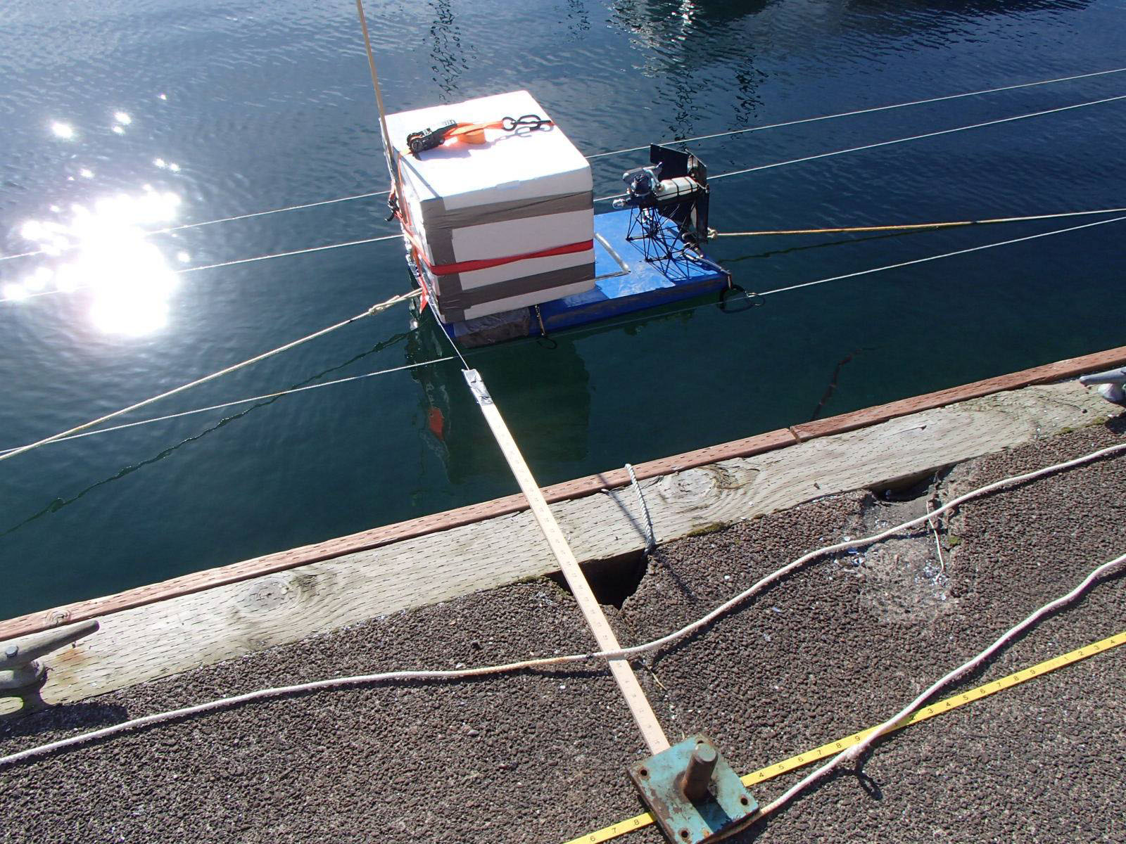 A foam box is rigged with a pulley system, allowing a drone to capture images of it from various distances.