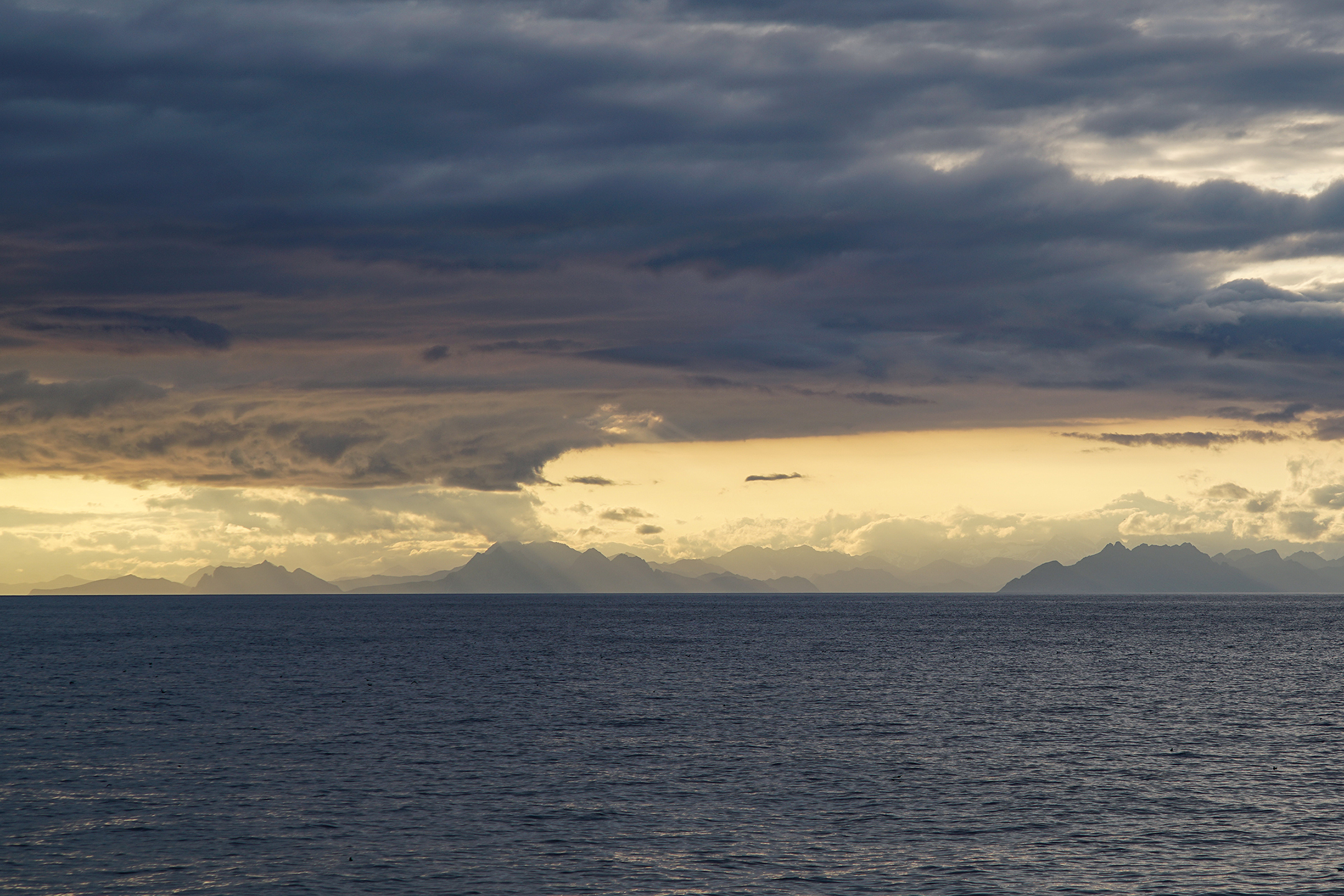 Dramatic clouds and Alaska’s southern coastline frame the Gulf of Alaska during a scientific cruise in summer 2017. 