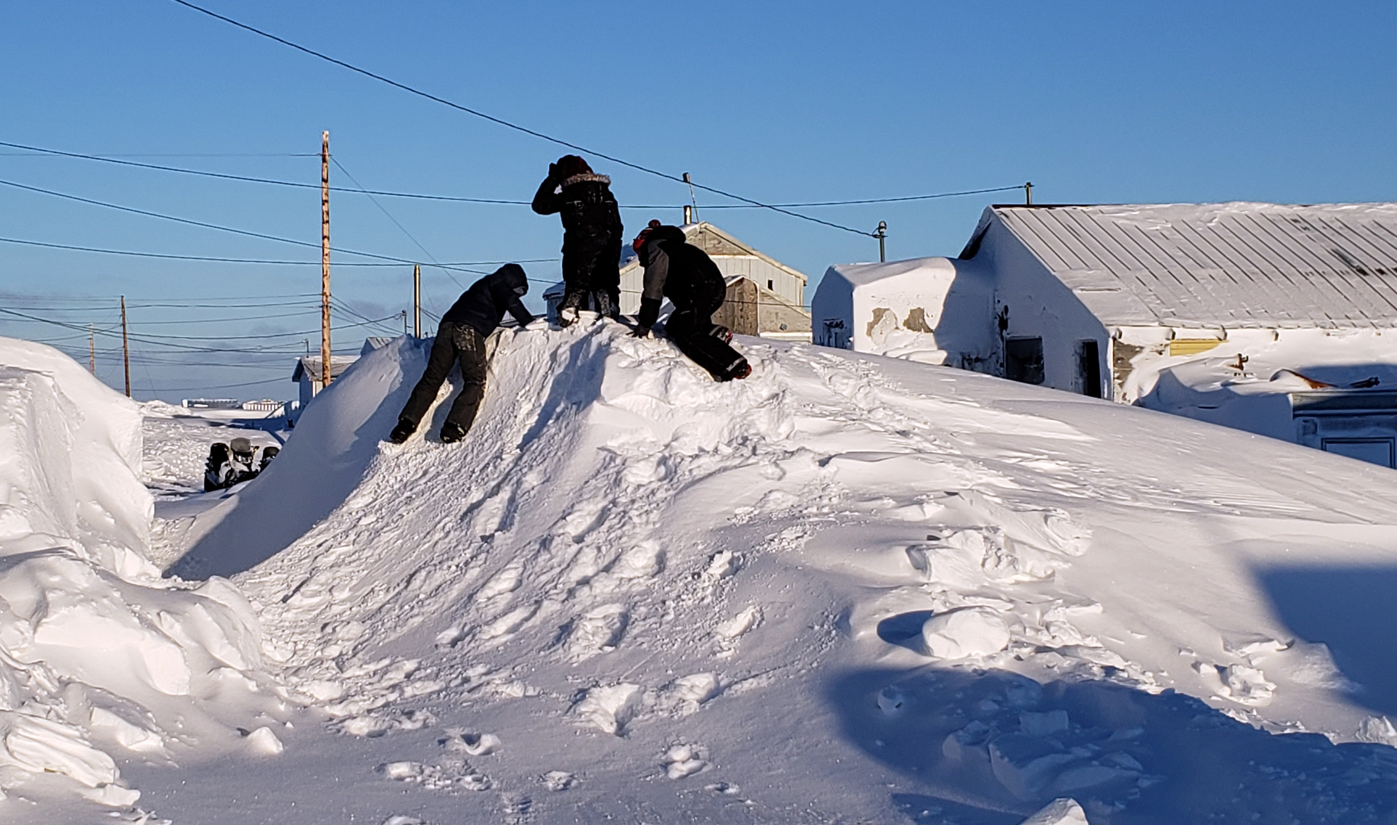 Children play on a hill of snow