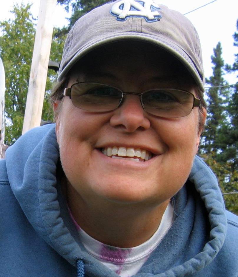 A woman in a ballcap and sweatshirt.