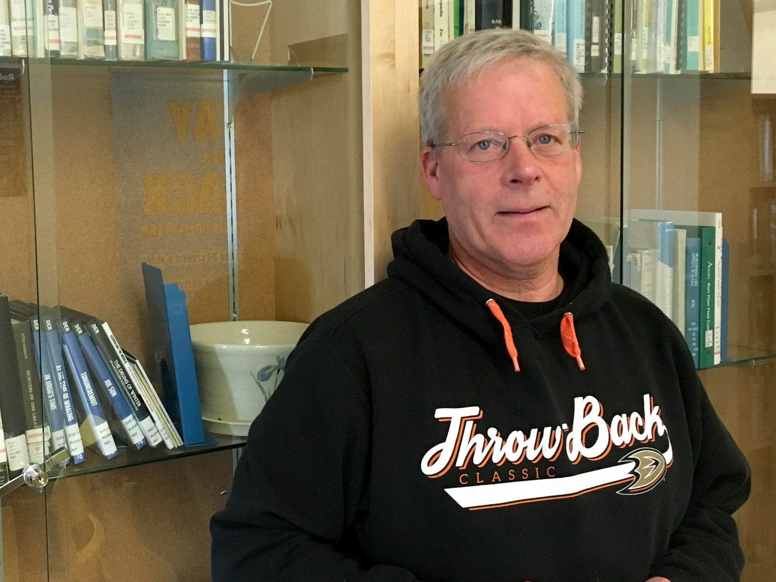 Man in a hoodie posing in a library