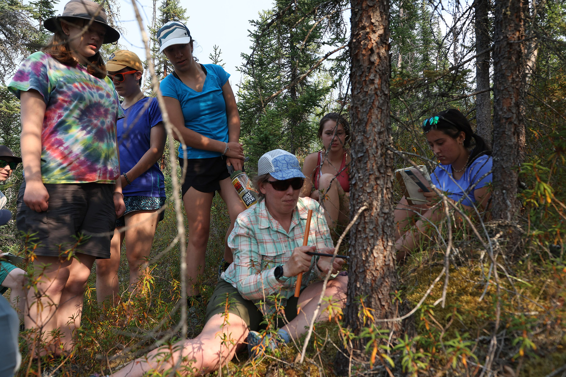 Girls in the Forest instructor Anna Talucci demonstrates tree coring.