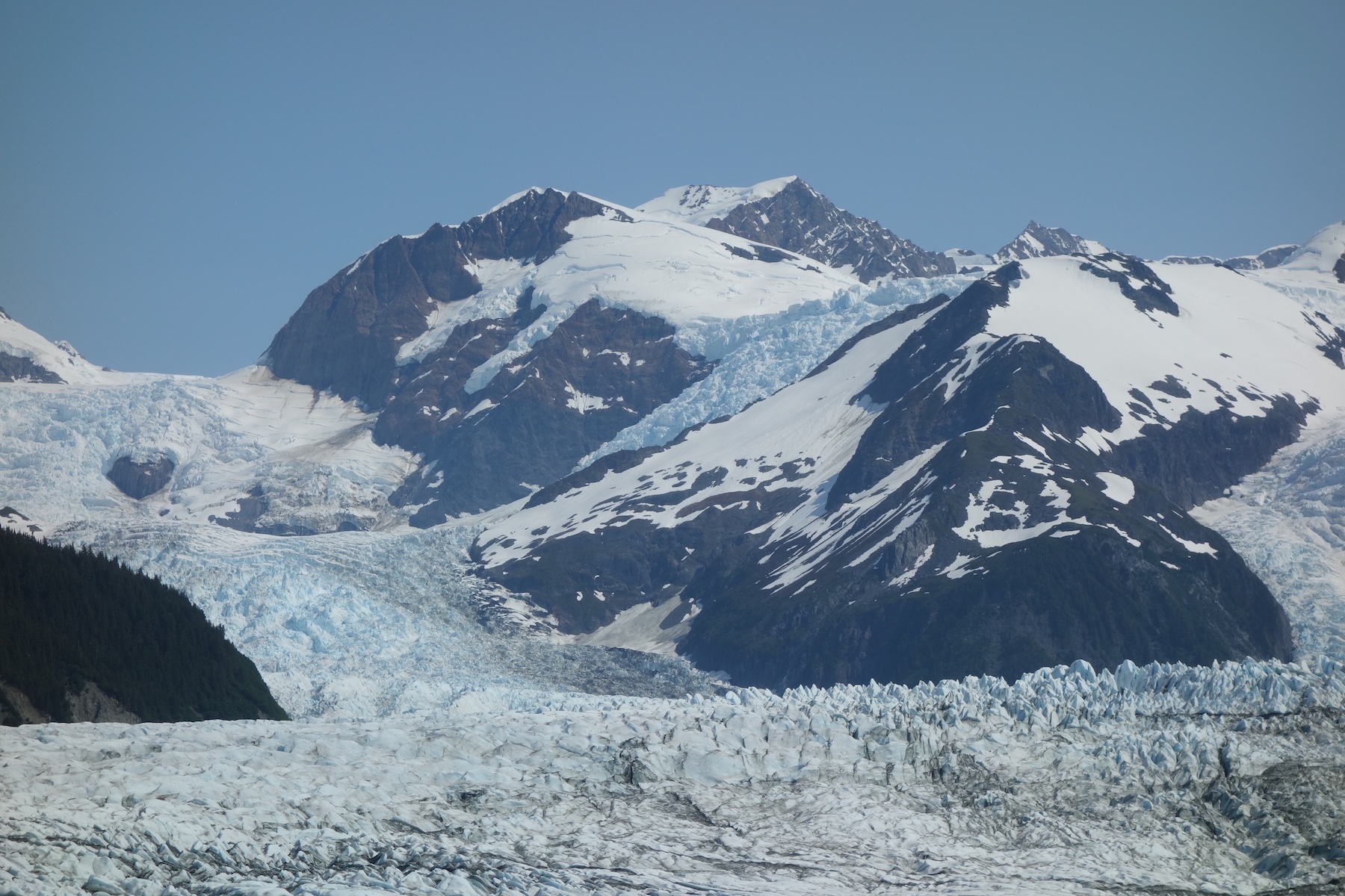 Mountains rise above jagged glacier ice.