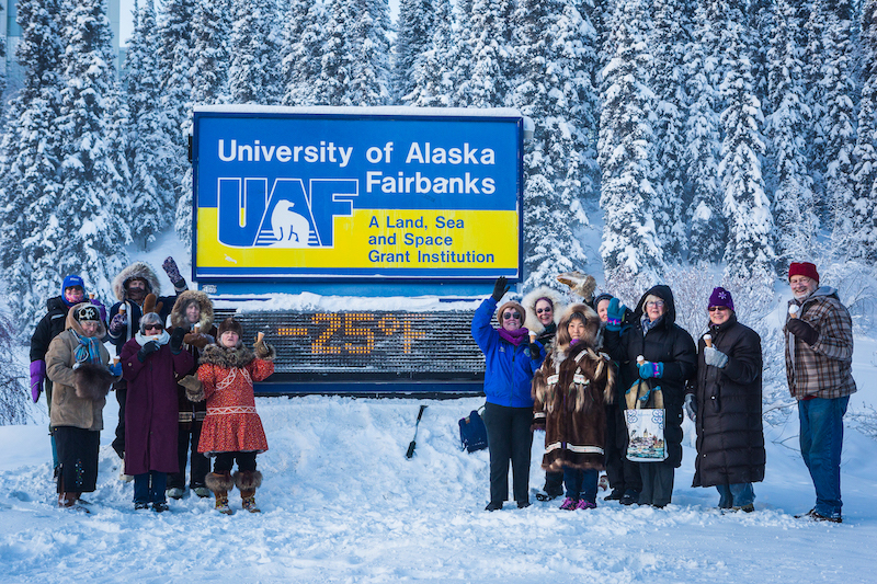 group of people in front of a -25 time and temperature sign