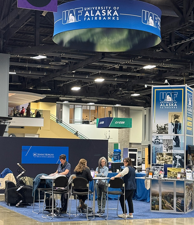 People setting up a booth before the opening of 2024 American Geophysical Union meeting.