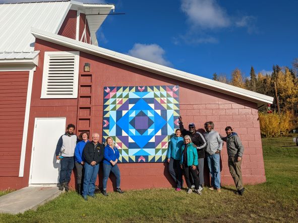 Members of the UAF Alumni Association board visit the Wild Blueberry and Troth Blossoms barn quilt on display at the Fairbanks Experimental Farm.