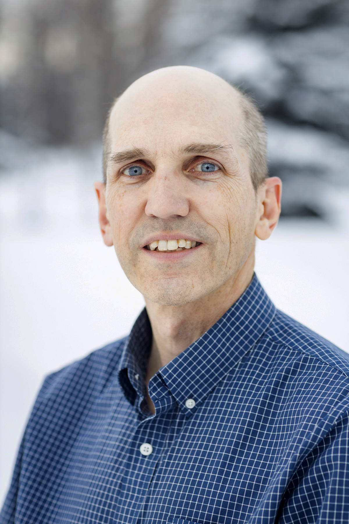 A portrait of a man in a blue shirt