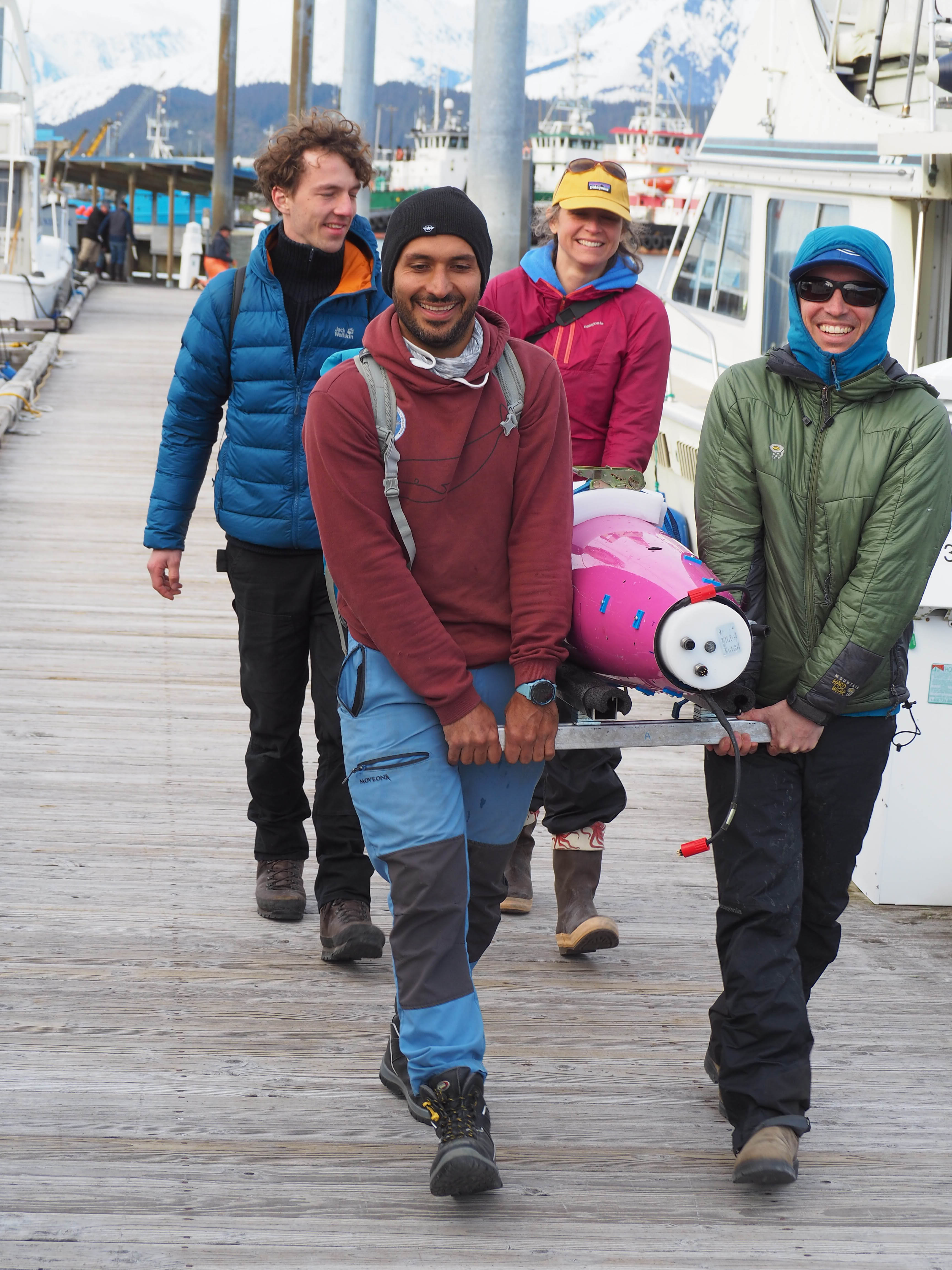 Four people carrying the seaglider to boat