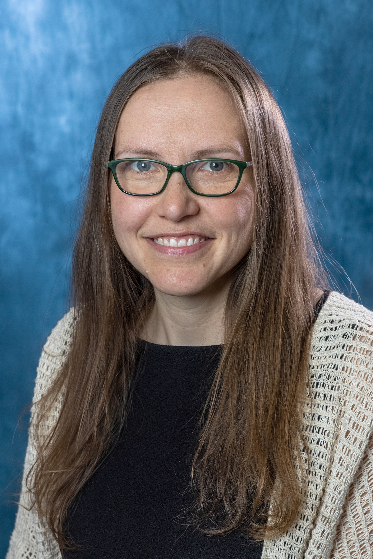 a portrait of a smiling woman wearing glasses