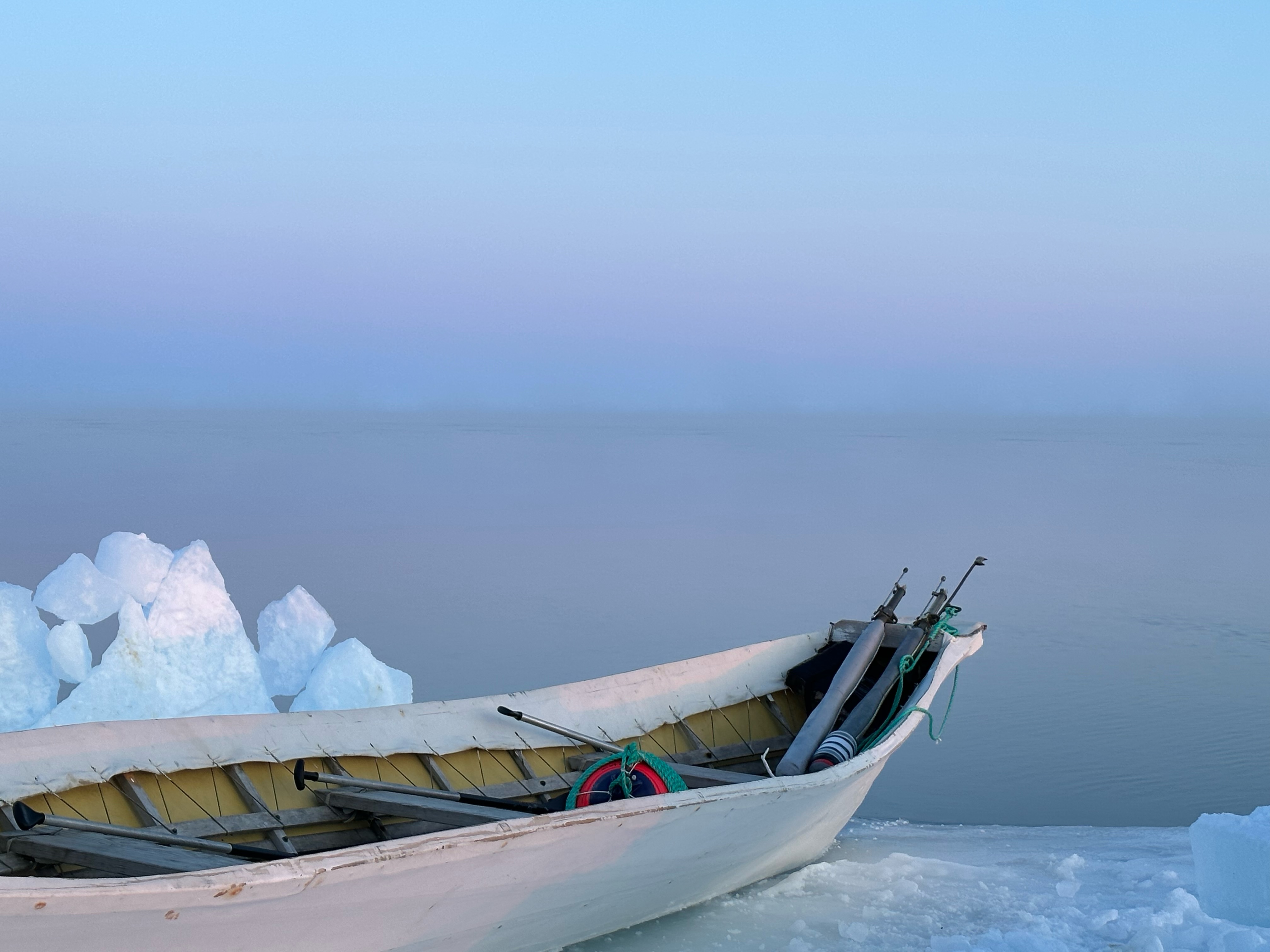 An umiak (skin boat) sits at the slushy ice edge of the Arctic Ocean