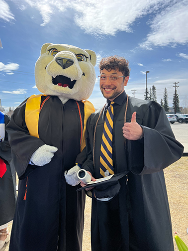 Kyle Agustines, a graphic designer with the UAF University Advancement team, takes a moment to celebrate his graduation with Nook.