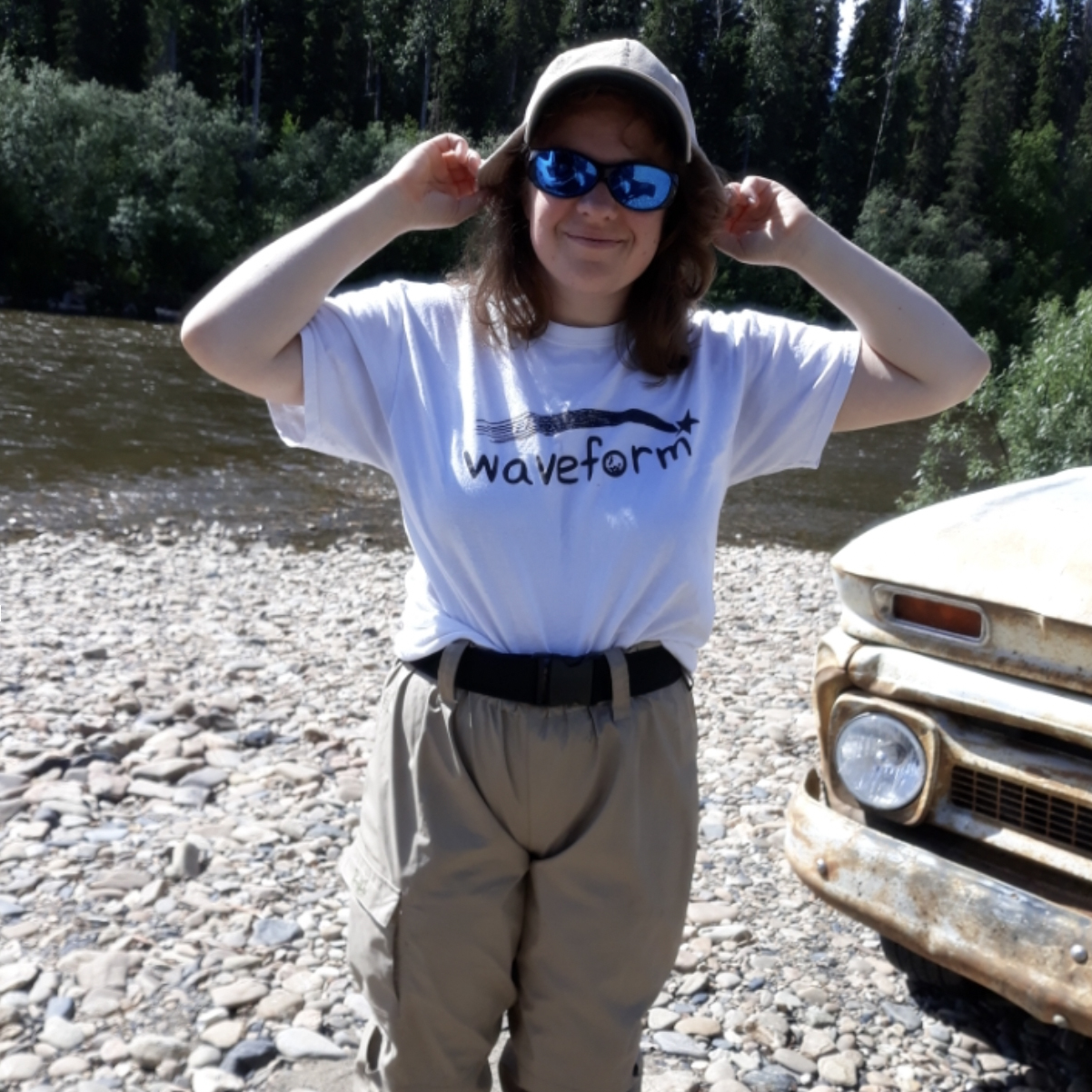 a woman  in a fishing hat and waders