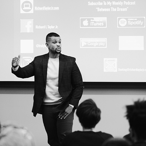 Black and white photo of national speaker and author Richard Taylor Jr. speaking to a room of students