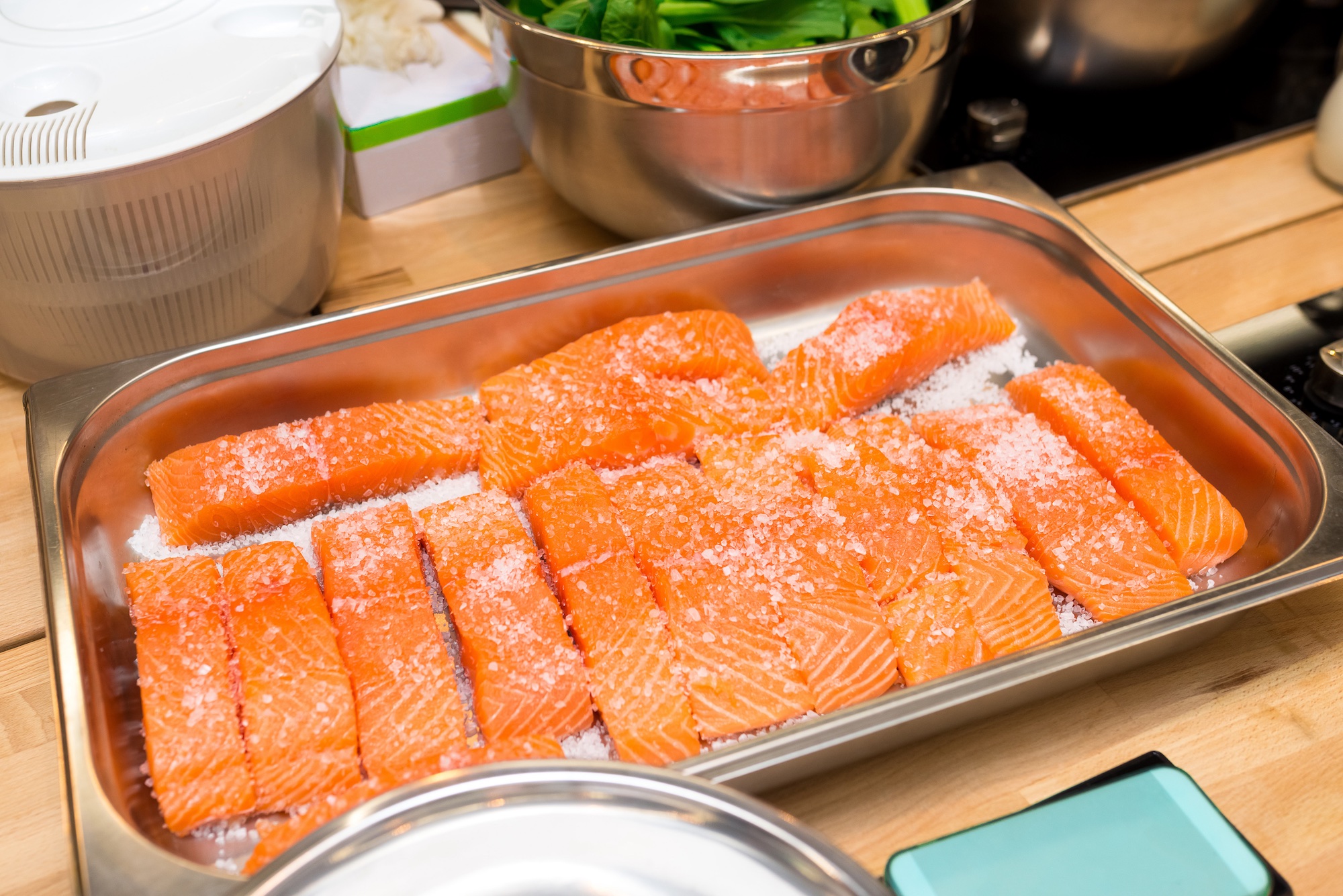 Pieces of salmon are laid out in a baking tray
