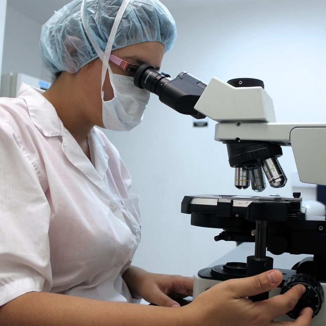 Woman looks through microscope