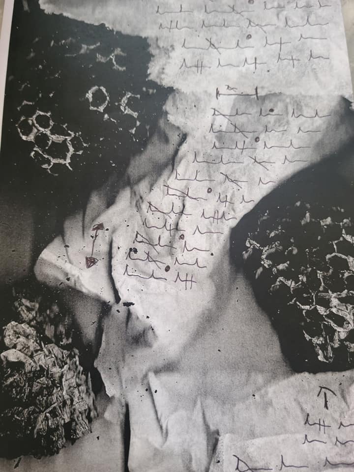 Abstract black and white image of crumpled paper overlaid with tallies and other markings