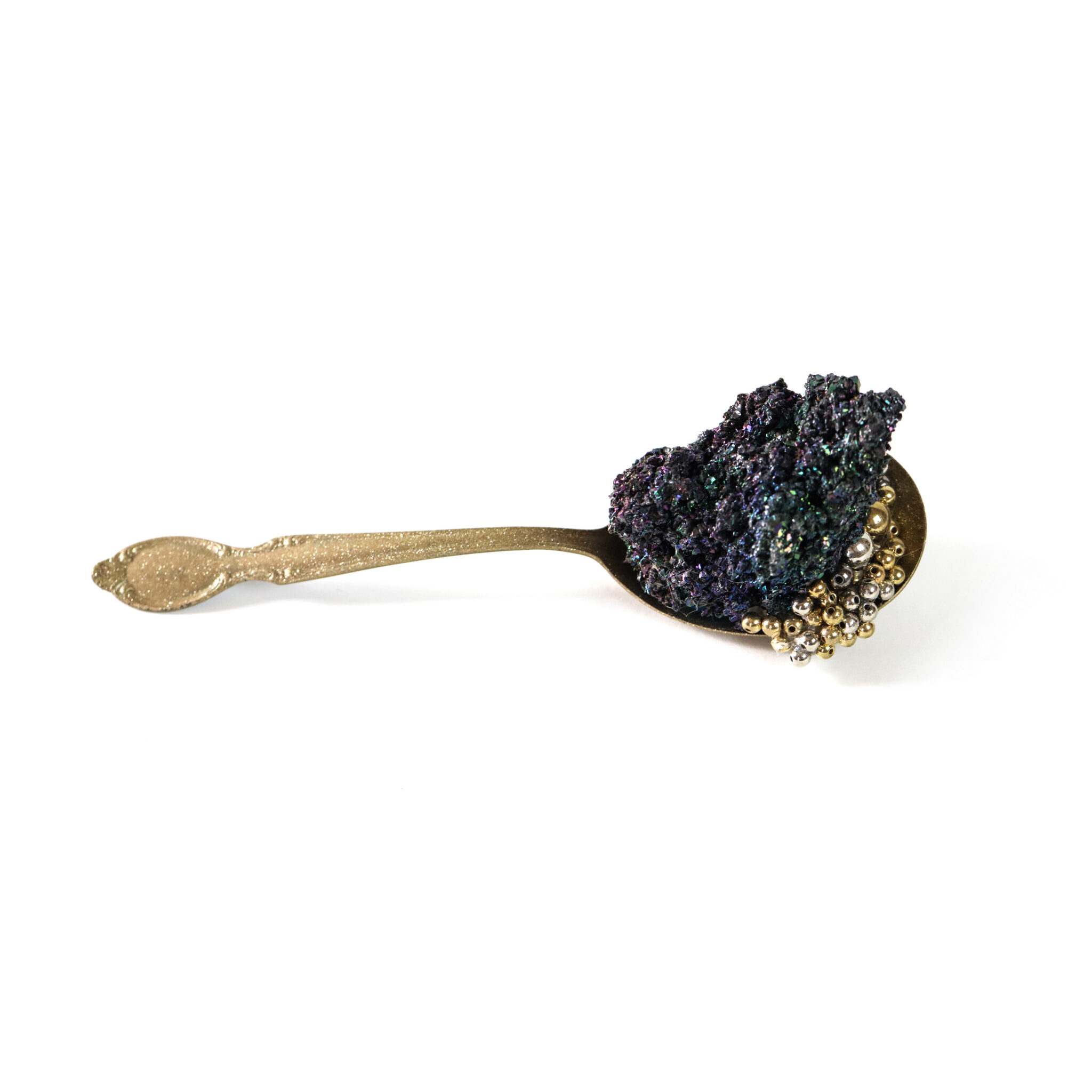 mixed media sculpture including a gold colored spoon holding multiple objects | Art by Sarah Walko