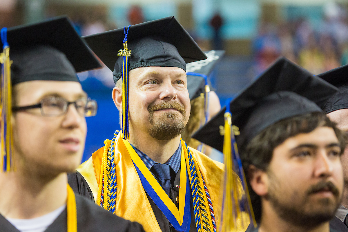 Troy Bouffard is all smiles after returning to his seat during the 2014 Commencement Ceremony Sunday, May 11, 2014 at the Carlson Center. Bouffard received a B.A., in Political Science, cum laude.. UAF Photo by JR Ancheta