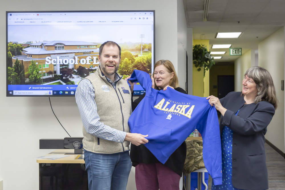 Political Science faculty Carol J. Gray and Amy Lovecraft present Gonzaga Director of Admissions Luke Cairney with a UAF sweatshirt. UAF Photo by Sarah Manriquez