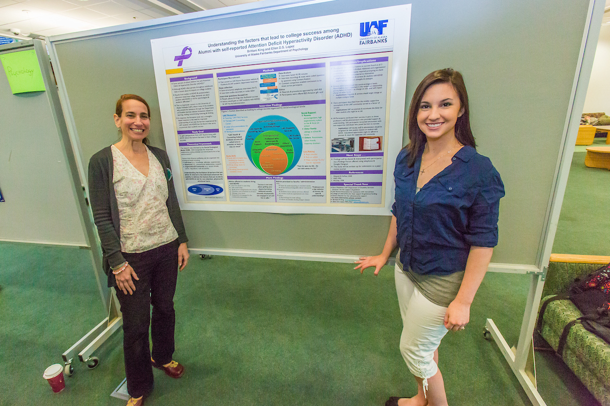 Psychology major Brittani King, rights, stands with Professor Ellen Lopez in front of her poster during UAF's Research Day Poster Session in Wood Center. | UAF Photo by Todd Paris