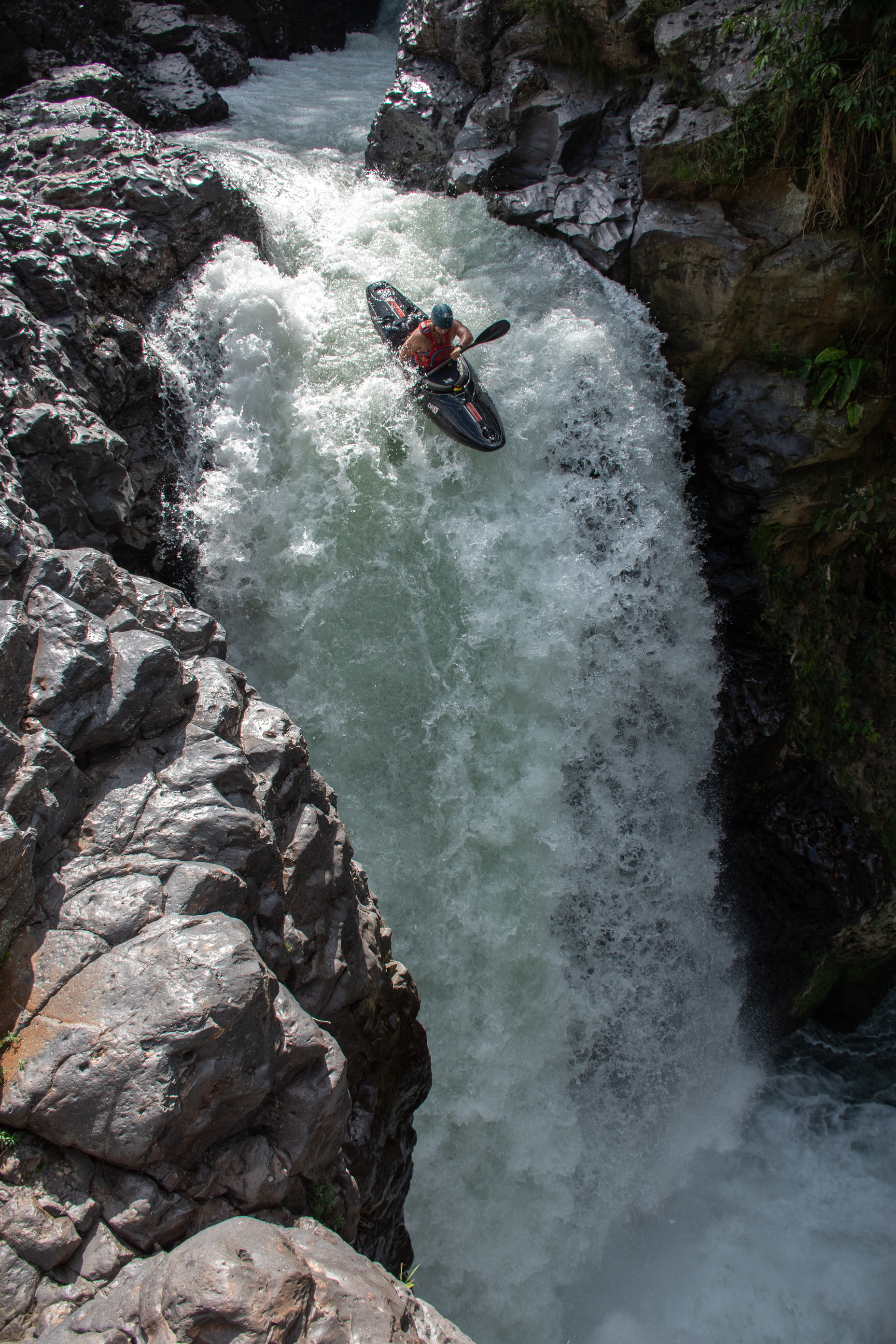 Sam paddling over a waterfall