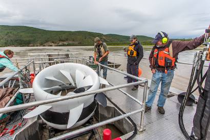 A biologist with the Alaska Department of Fish and Game, sets up a net housed under a turbine placed in the Tanana River near Nenana.