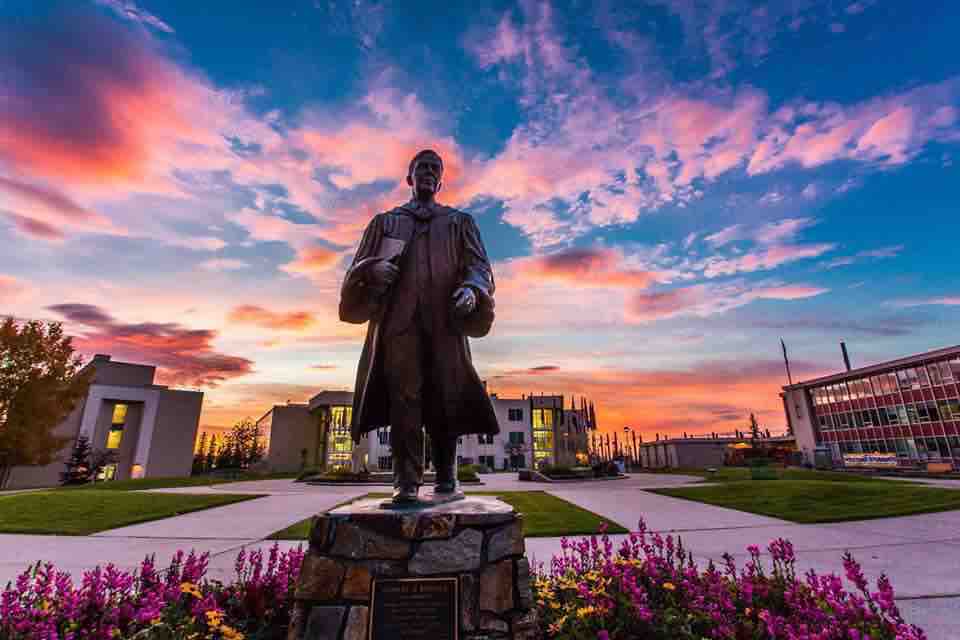 The Bunnell statue stands in Cornerstone Plaza on the Fairbanks Campus with the summer sunset in the background