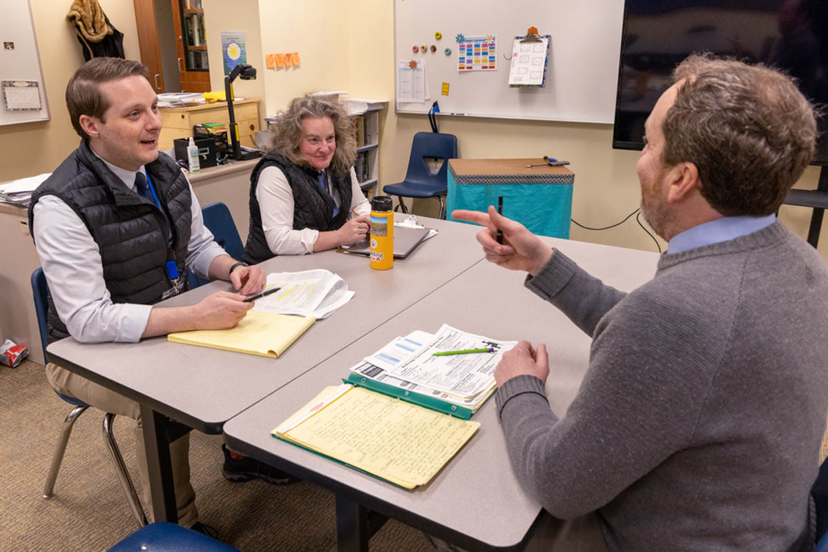 Advisors socialize at a table meeting