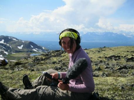 Photo of Adrina Knutson outdoors holding audio equipment