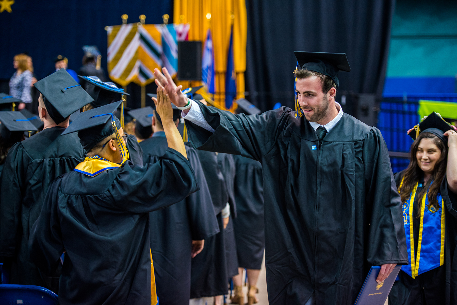 UAF Film graduate Mark Stoller high fives Daniel Nero after both Nero and Stoller received their diplomas at Commencement 2017. | UAF Photo by Zayn Roohi
