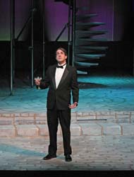 Raising a toast to the stars: a man on stage holds a champagne glass, his gaze uplifted in anticipation.