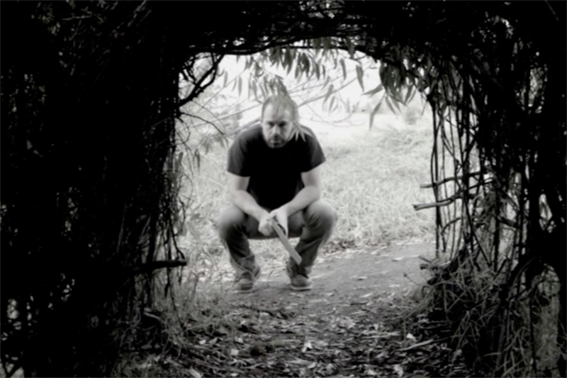 August, played by Mallory Smyth, crouches down to look through a branch covered tunnel. UAF Photo